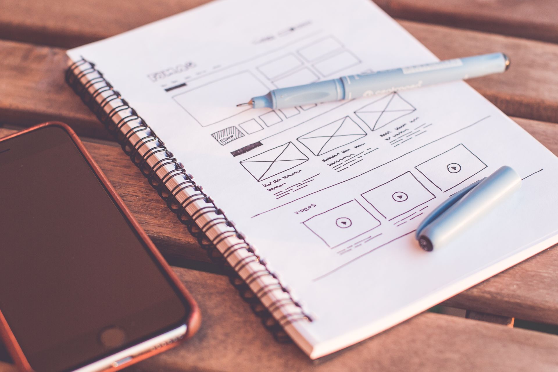 Designer sketching website wireframes in a notebook
